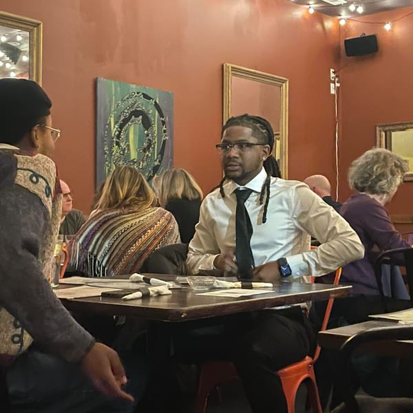 Diners seated at tables in Succotash Southern and Creole Kitchen, with warm lighting and art on the walls.